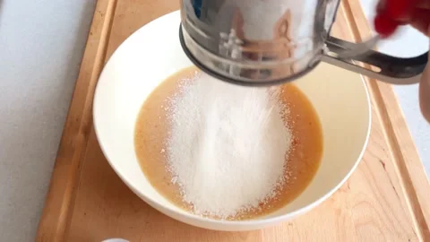 Add flour to the dough, sift and mix well in a white bowl Stock Footage 225043801