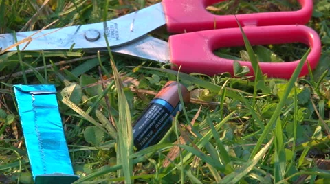 Add to a frame gum in blue foil, scissors and penlight batteries Stock-Footage 63209622