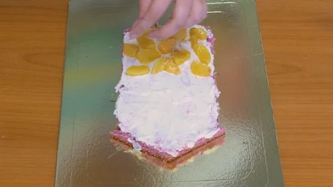 Add fruit to the cream layer of the cake Stock-Footage 123576939