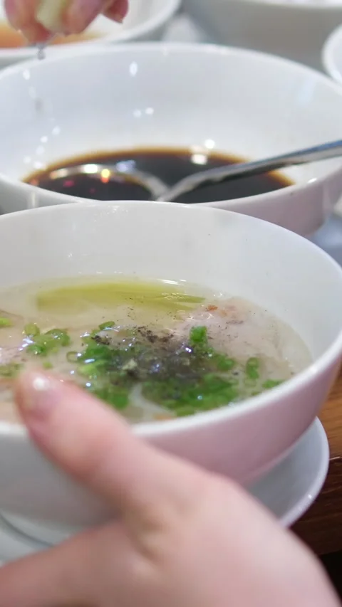 Add lime sprinkle with lime drops Vietnamese Pho bo Soup Close-up of hands Stock Footage 310158051