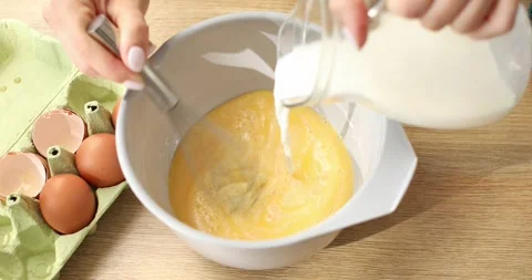 Add milk and beat with eggs and flour. Cooking butter for baking. Stock Footage 248727548