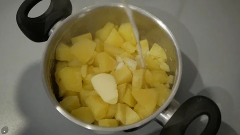 Add milk to the pan with boiled potatoes Stock Footage 98134604