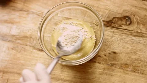 Add minced garlic to the mustard. 4k cinematography video recipe Stock Footage 156445447