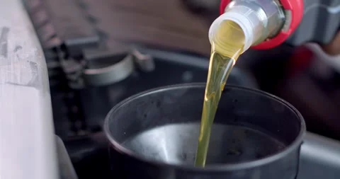 Add new engine oil to the engine. Extreme close up.New engine oil golden yellow. Stock Footage 267274907