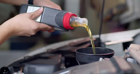 Add new engine oil to the engine. Extreme close up.New engine oil golden yellow. Stock Footage 283484945