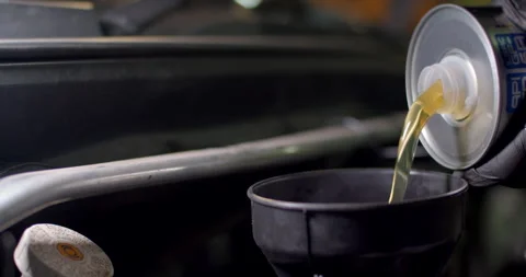 Add new engine oil to the engine.Change new oil to the car engine. Stock Footage 295799990