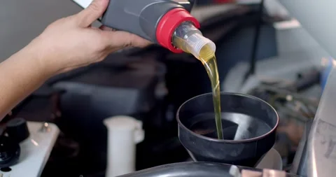 Add new engine oil to the engine.Close up engine oil. New golden yellow engine. Stock Footage 267277582