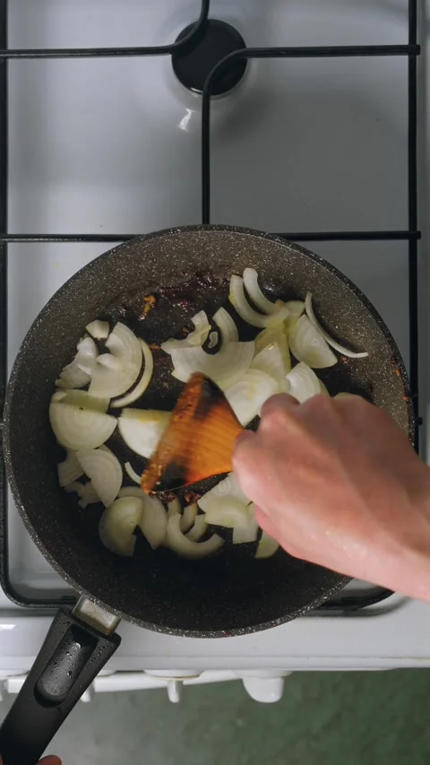 Add onion in frying pan Vídeos de archivo 345481098