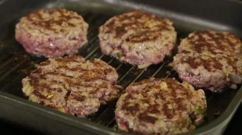 Add salt and pepper to the roasting cutlets for cheeseburgers on the grill pan Stock Footage 49781346