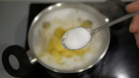 Add salt to the pan with potatoes Stock Footage 98134587