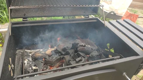 Add some coal to the grill Stock Footage 155630496