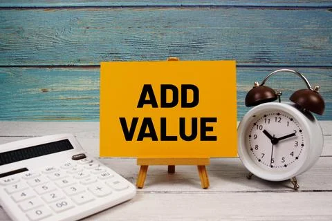 Add Value text written on paper card with calculator and alarm clock on woo.. 스톡 사진