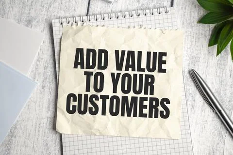 ADD VALUE TO YOUR CUSTOMERS note on wooden background and pen Stock Photos