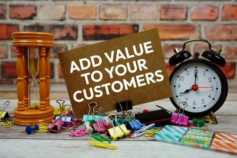 Add value to your customers text on paper card with alarm clock and Stock Photos