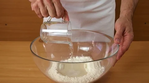 Add water into flour. Making Puff Pastry Series. Stock Footage 77222331