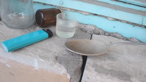 An addict is preparing a dose of drugs for himself. In unsanitary conditions. Stock Footage 126932968