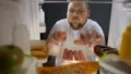Addicted young man eating sausages at night near fridge, unhealthy nutrition HD Footage