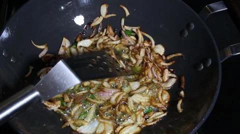 Adding and cooking chopped okra to the fried onions and mixing Stock Footage 65214492