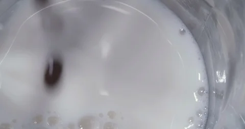 Adding and mixing black cofee with milk Stock Footage 92170010