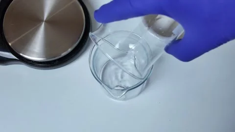 Adding and Mixing Material in Glass Beaker Stock-Footage 345259434
