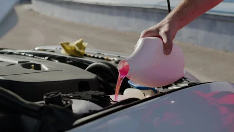 Adding antifreeze to car vital for protecting engine from freezing and Stock Footage 272453142