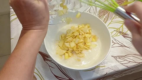 Adding apples to cake batter, Marina di Carrara, Italy, October 16, 2026 Stock Footage 347878414
