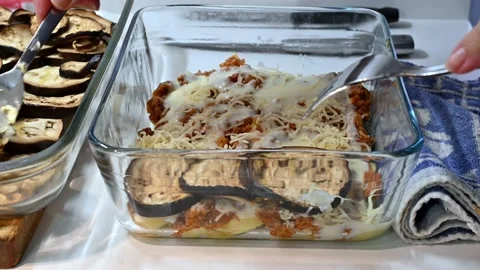 Adding the aubergines to the moussaka Stock Footage 219879217