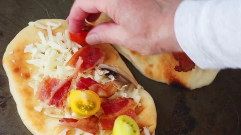 Adding bacon, mushrooms and cheese to pizzas Stock Footage 91447601