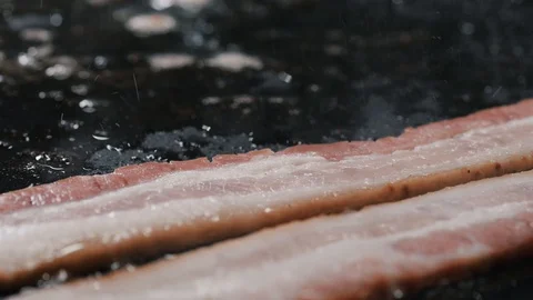 Adding bacon slices unto a frying pan Video stock 102569832