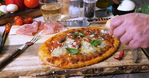 Adding basil leaves to an Italian pizza margherita Stock Footage 75540189