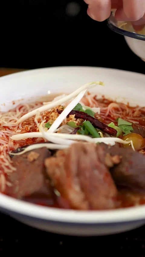 Adding Bean Sprouts to Northern Thai Curry Noodle Soup Stock Footage 314538613