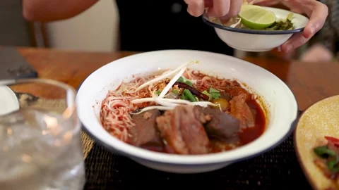 Adding Bean Sprouts to Northern Thai Curry Noodle Bowl Stock Footage 314691332