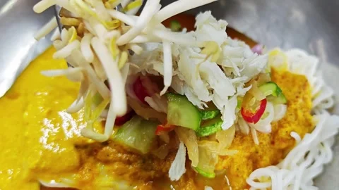 Adding bean sprouts topping on Thai rice noodles with crab curry. Video stock 342516156