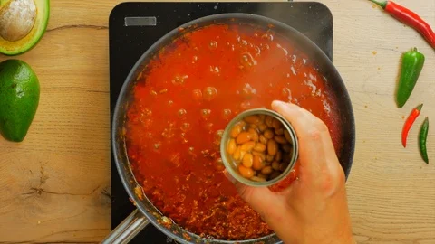 Adding beans to chilli con carne Stock Footage
