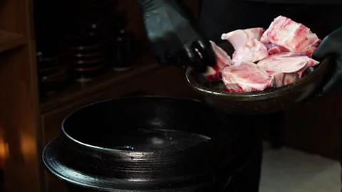 Adding Beef Bones into Traditional Cauldron Stock Footage 334638474