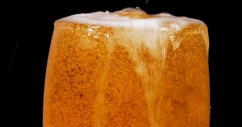 Adding beer into glass and it overflows closeup isolated Stockbeeldmateriaal 121887047