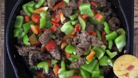 Adding bell peppers to a stir fry Stock Footage