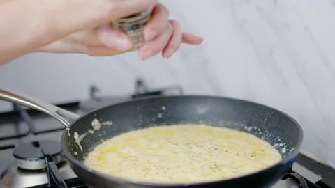 Adding black pepper into a cream sauce in a frying pan in 4K. Stock Footage 138067036