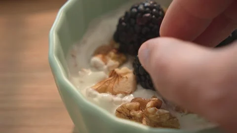 Adding blackberry to yogurt with oats and walnuts Stock Footage 312708269