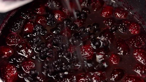 Adding blueberries to raspberry sauce. Stock Footage 141931900