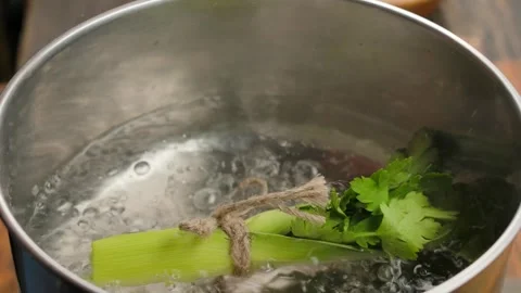 Adding a Bouquet Garni to Boiling Broth. Close-up Stock Footage 311060296