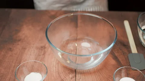 Adding in a bowl and mixing Ingredients for pizza dough on a wooden table in 4K. Stock Footage 137425348
