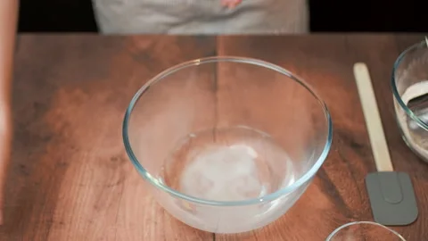 Adding in a bowl and mixing Ingredients for pizza dough on a wooden table in 4K. Stock Footage 137425438