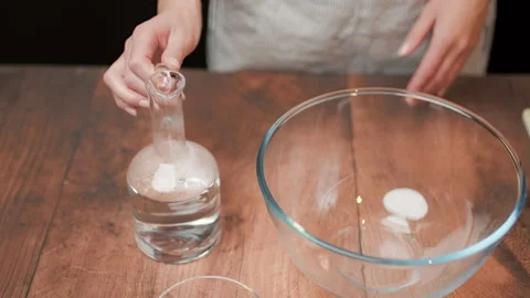 Adding in a bowl and mixing Ingredients for pizza dough on a wooden table in 4K. Stock Footage 137425713