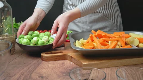 Adding a bowl of Brussels Sprout vegetables into an oven pan for roasting in 4k. Stock Footage 145115555