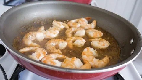 Adding Broccoli to Pan With Shrimp Simmering in Sauce Stock-Footage 128214584