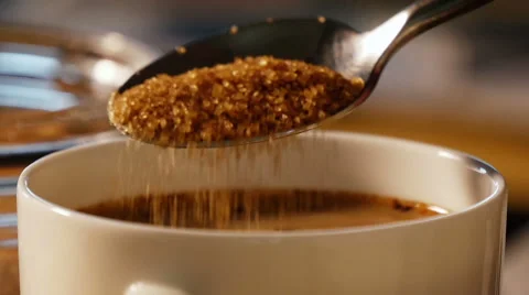 Adding brown sugar to coffee slow motion Stock Footage 49743361