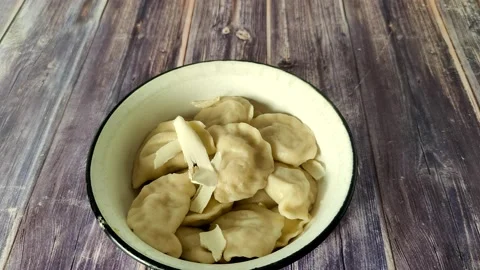 Adding butter to boiled dumplings with potatoes in a bowl. Stock Footage 232219202