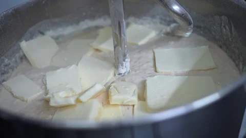 Adding butter in a mixer to knead bread dough Stock Footage 251347248
