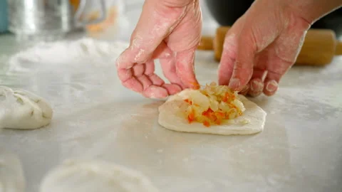 Adding cabbage and carrot filling to the dough for pies Stock Footage 320636822
